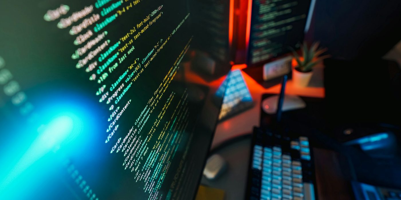 Lines of code on a monitor in a dimly lit workspace