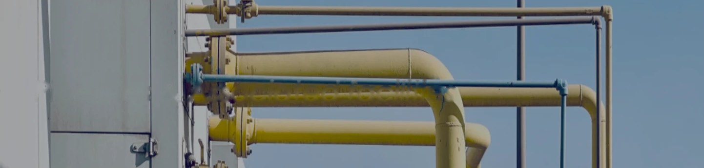 Yellow and blue process pipework against a clear sky